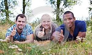 Three young people showing thumbs up