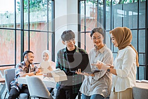 three young people using laptop with cafe as a background