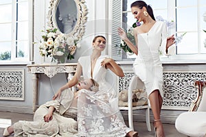 Three young pretty lady in white lace fashion style dress posing in rich interior of royal hotel room, luxury lifestyle