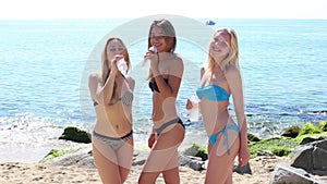 Three young smiling girls wearing swimwear