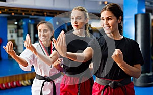 Three young smiling women practicing in karate