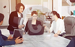 Three young successful business women in the office, together, happily working on a project