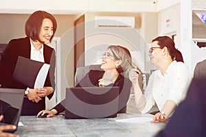 Three young successful business women in the office, together, happily working on a project