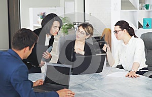 Three young successful business women in the office working together on a project