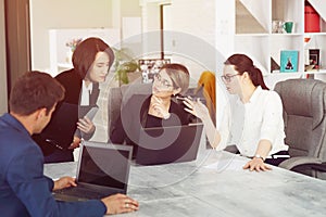 Three young successful business women in the office working together on a project