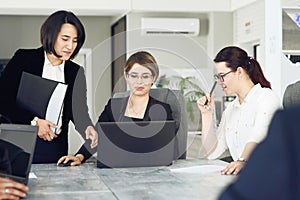 Three young successful business women in the office working together on a project