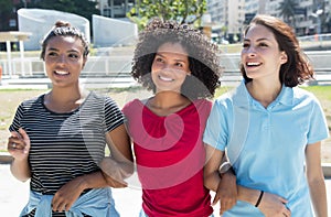Three young woman walking in city