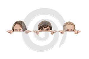 Three young women behind a blank banner ad