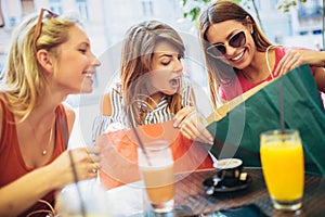 Three young women in a cafe after a shopping