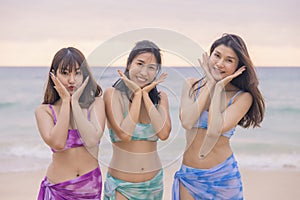Three young women friends happily wear this bikini on a beach in Nai Thon Beach, Phuket Province, Thailand. Portrait of happy