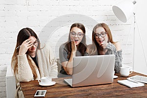 Three young women friends with laptop.