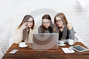 Three young women friends with laptop.