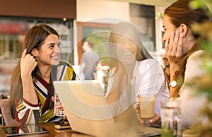 Three young women having conversation in cafe.