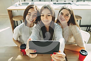 Three young women having fun and taking selfie