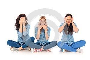 Three young women making the no evil poses sitting