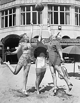 Three young women playing with a ball on the beach photo