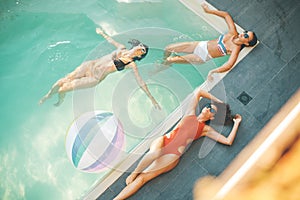 Three young women relaxing in the swimming pool