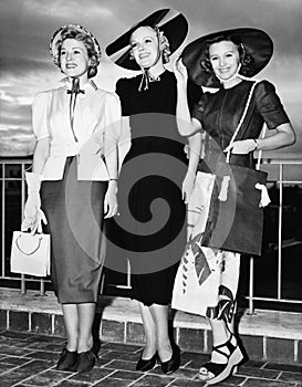 Three young women standing side by side and smiling