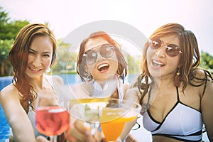 Three younger asian woman happiness  drinking beverage in waer swimming pool