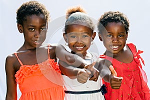 Threesome african girls doing thumbs up together.