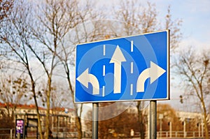 Threeway blue sign on the side of a road at daytime photo
