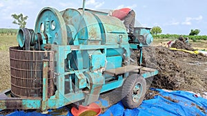 Thresher machine operator cleaning to machine.