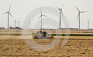 Threshing machine working on a summer field, windmill blade back