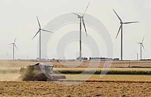 Threshing machine working on a summer field, windmill blade back