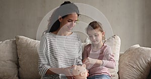 Thrifty little girl puts coins into piggy bank