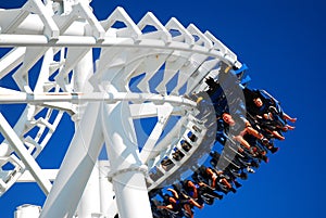 Thrill seeks zoom around a curve on a roller coaster