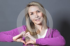 Thrilled 20s woman showing heart shape with hands