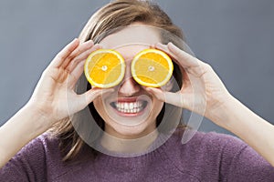 Thrilled beautiful girl with zesty orange slices for optimistic vision photo