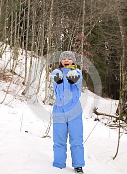 Thrilled child screaming for fun with snow clothes playing outdoor photo
