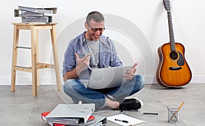 Thrilled creative entrepreneur sitting on floor to relax and work