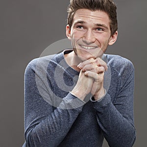 Thrilled happy young male student with hands sitting