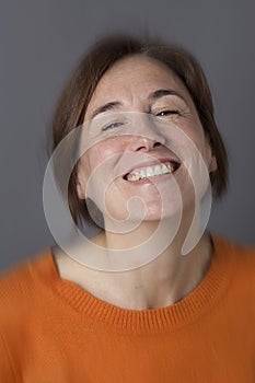 Thrilled middle aged woman with brown hair laughing, blur effects