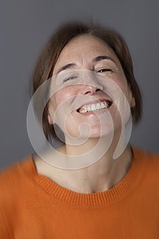 Thrilled middle aged woman with brown hair laughing, blur effects photo