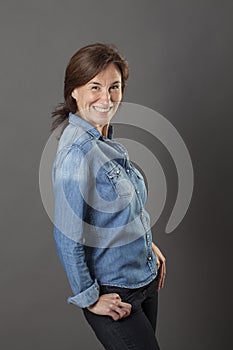 Thrilled middle aged woman with hands in pockets standing