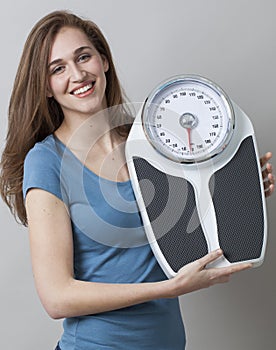 Thrilled young woman proud of displaying her kilos or pounds loss