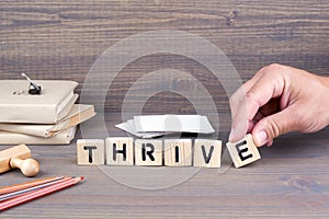 Thrive. Wooden letters on dark background