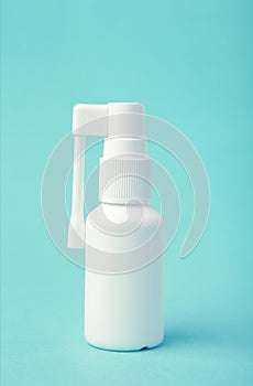 Throat spray medication in a white bottle on light blue background