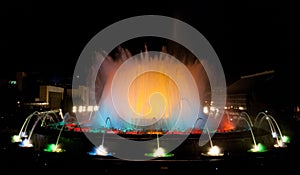 Throngs of people at the colourful light & water fountain show. Night in Barcelona, Spain, at the magic fountain.