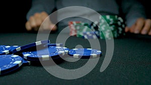 Throw the blue chips in poker. Blue and Red Playing Poker Chips in Reflective black Background. Closeup of poker chips
