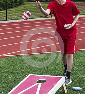 Throwing bean bag during corn hole game