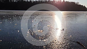 Throwing a chunk of ice that crushes on a frozen lake. Sunny winter day. Slow