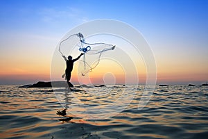 Throwing fishing net during sunrise