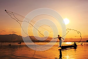 Throwing fishing net during sunset