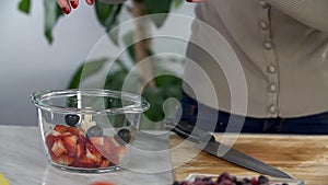 Throwing grapes in glass bowl