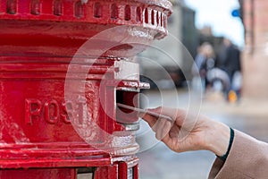 Throwing a letter in a red British post box