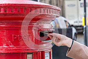 Throwing a letter in a red British post box